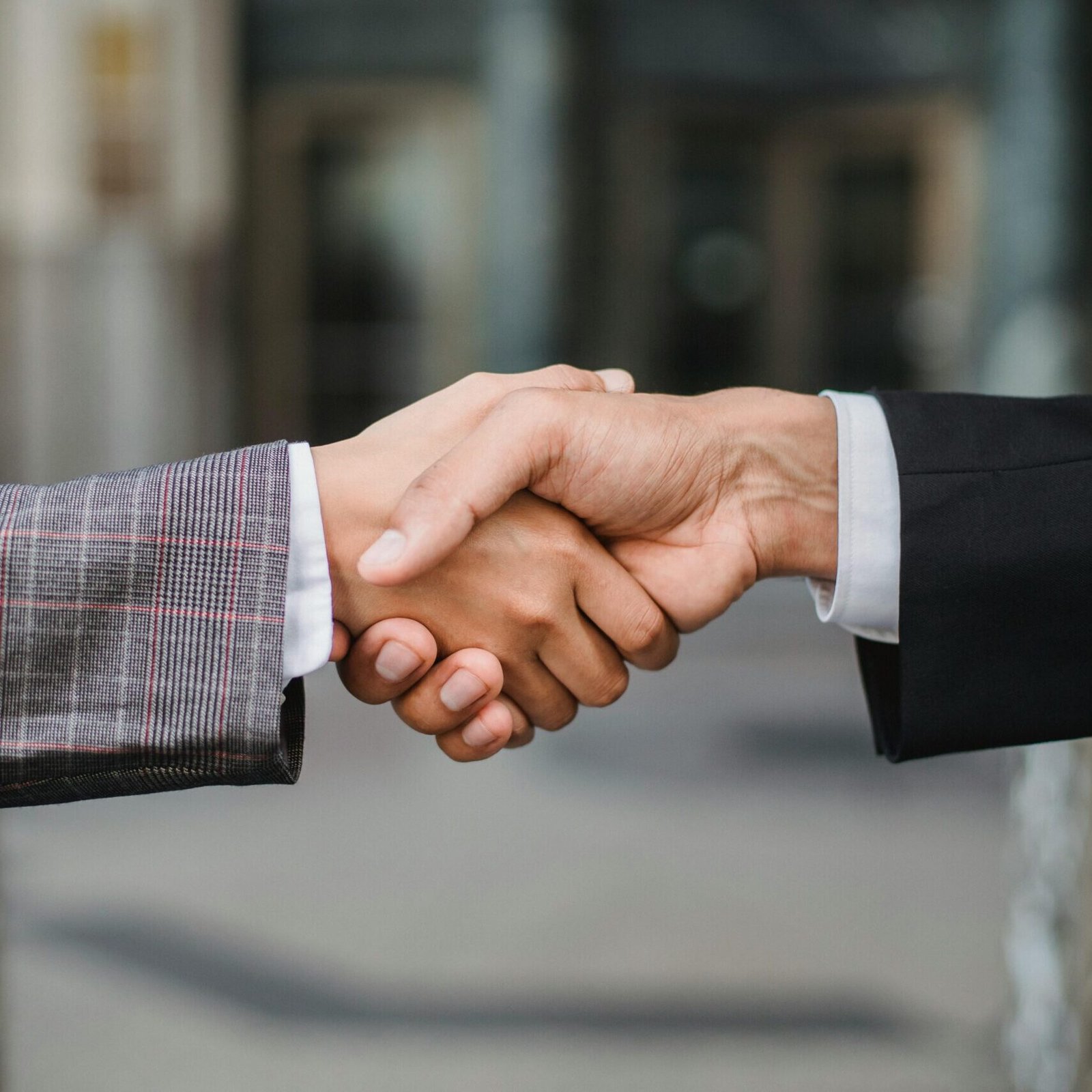 A close-up of two businesspeople shaking hands, symbolizing cooperation and partnership.